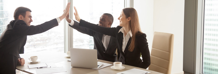 we can see 3 people celebrating success at work at a office space